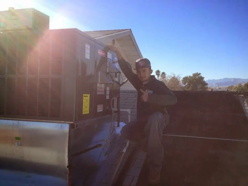 HVAC technician performing HVAC Inspection on a rooftop unit in Kermit